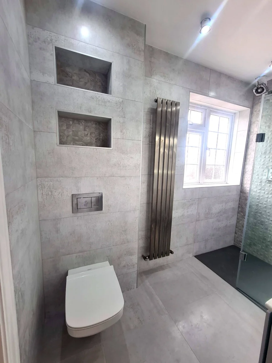 Grey tiled bathroom with wall-hung WC and built-in niches